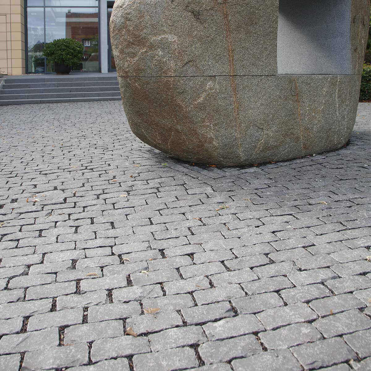 öffentlicher Platz mit Basalt Pflaster großer Findling in der Mitte