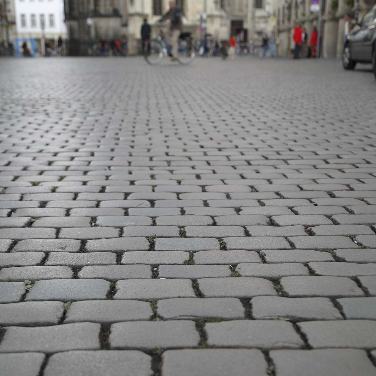 Granitpflaster gebraucht Rotbunt öffentlicher Platz mit Fahrzeugen und Fahrrädern
